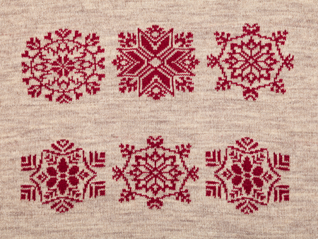Brown knitted fabric with red christmas ornamentの写真素材