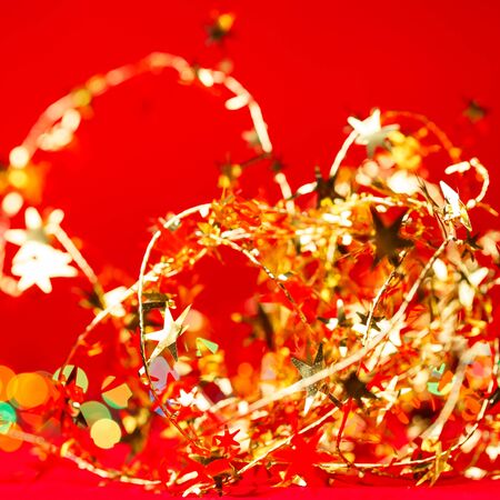 Christmas decoration with yellow tinsel on red backgroundの写真素材