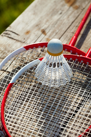 Badminton racquets with plastic shuttlecock on a bench close-upの写真素材