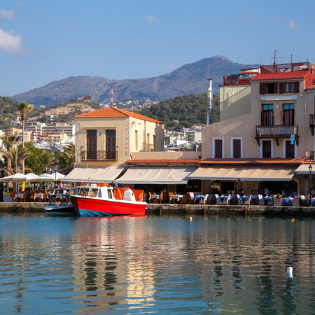 Waterfront cafe overlooking old venetian harbour and port at Rethymno (Rethymnon), island of Crete, Greece, Mediterraneanのeditorial素材