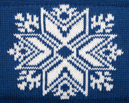 Deep blue knitted fabric with snowflake christmas ornamentの写真素材