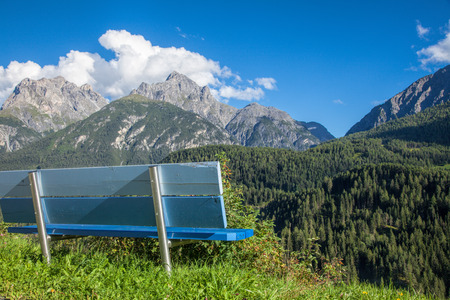 Bench overlooking Lower Engadine Alpine valley in Switzerland on a sunny summer dayの写真素材
