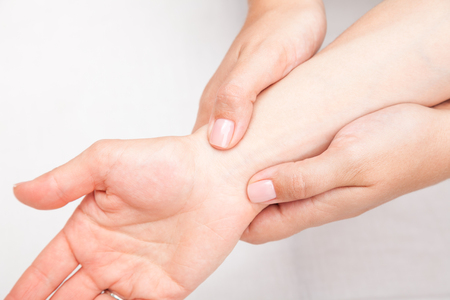 Young woman's wrist being manipulated by osteopathic manual therapist or physicianの写真素材