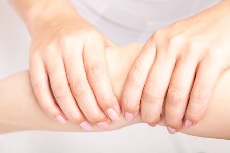 Young woman's elbow joint being manipulated by osteopathic manual therapist or physicianの写真素材