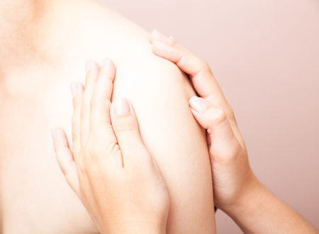 Young woman's shoulder joint being manipulated by osteopathic manual therapist or physicianの写真素材