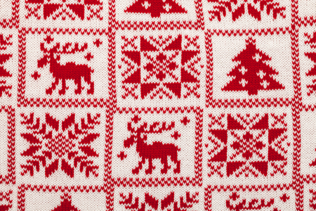 Red knitted fabric with scandinavian christmas ornamentの写真素材
