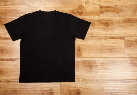 Black plain short sleeved cotton T-Shirt on a planket wooden backgroundの写真素材