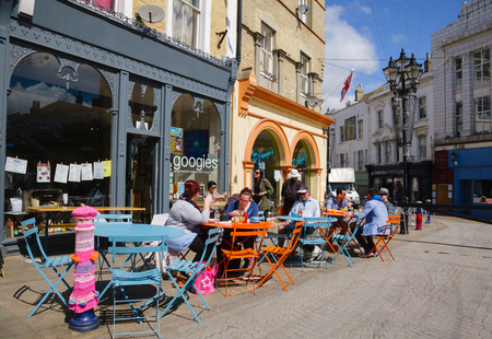 FOLKESTONE, UK - JUN 3, 2013: Customers dining at a sidewalk cafe on a sunny summer dayのeditorial素材