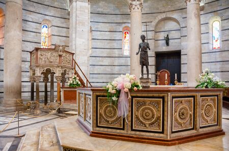 PISA, ITALY - MAY 31, 2018: Pisa Baptistery of St. John (Pisa Baptistry) at Piazza dei Miracoli (Piazza del Duomo) interior with  octagonal font by Guido Bigarelli da Como, pulpit by Nicola Pisano and bronze sculpture of St. John the Baptist by Italo Grisのeditorial素材
