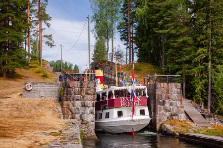 EIDSFOSS, NORWAY - JULY 18, 2018: M/S Henrik Ibsen ferry boat entering lock chamber at the Eidsfoss lock during a unique historical boat trip through spectacular Norwegian nature by the Telemark Canalのeditorial素材