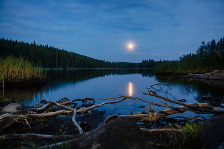 Summer landscape with full moon reflects in a lake at night, Telemark Southern Norwayの写真素材