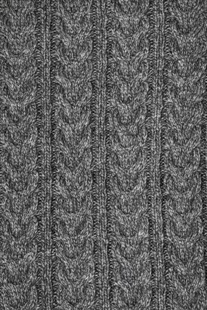 Grey melange knitted fabric with cable pattern made of heather mixed yarn background