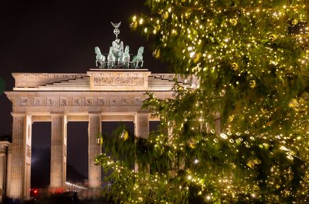 Illuminated Neoclassical Brandenburg Gate (Brandenburger Tor) and Christmas Tree as viewed from the Pariser Platz, Mitte, Berlin, Germanyの写真素材