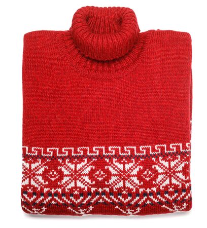 Red knitted Christmas turtleneck sweater or pullover of traditional design with white Scandinavian geometric ornament laid folded on white backgroundの写真素材