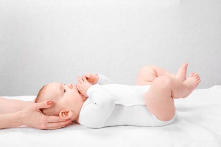 Six month baby girl receiving osteopathic or chiropractic treatment in pediatric clinic. Manual...