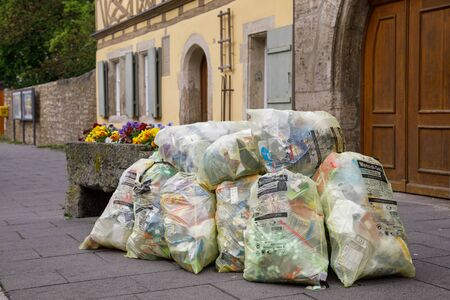 Rothenburg ob der Tauber, Germany - May 9, 2019: Pile of yellowish Wertstoffsack garbage bags...