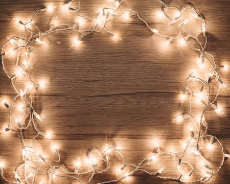 Vintage Christmas lights frame on wooden backgroundの写真素材
