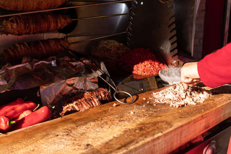 Chef chopping grilled lamb intestines making traditional turkish street food Kokorech (Kokorec) in...