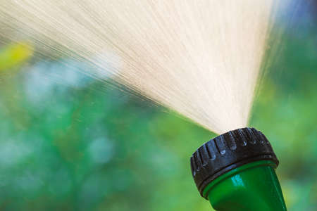 Irrigation sprinkler spaying water irrigating summer garden