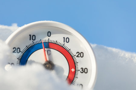 Thermometer with celsius scale in the snow showing minus 4 degree ambient temperature - winter...