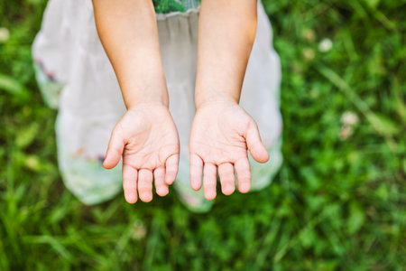 Little girl showing her clean hands after washing outdoorsの写真素材