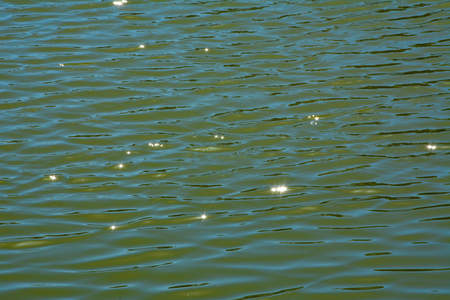 Sun rays reflecting star effect in water surfaceの写真素材