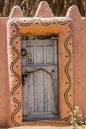 ancient wooden door and clay fenceの写真素材