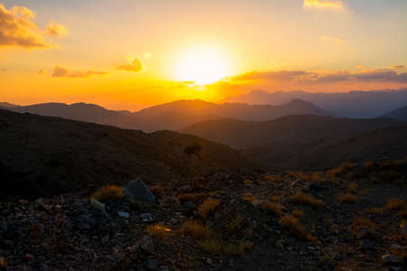 Beautiful mountain sunset with dramatic clouds and trees silhouette, Located in Banisad, Saudi arabiaの写真素材