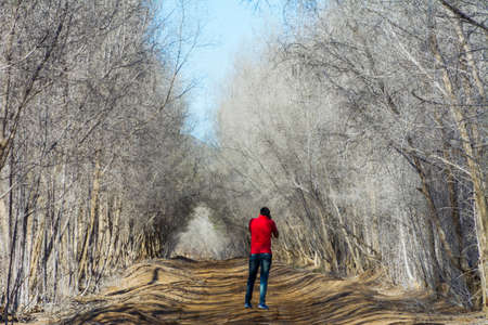 Photographer at Beautiful countryside pathway in autumn with leafless trees