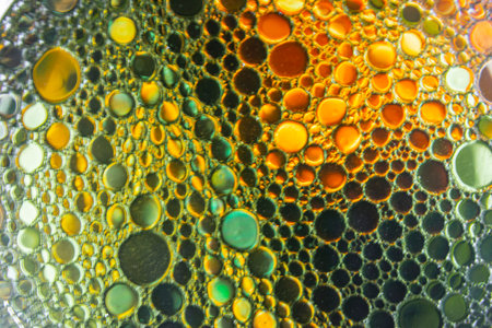 Bright and unique oil drops, circles on the water surface. Unusual background. Colorful background...
