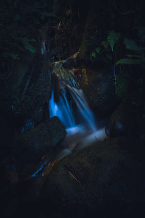 long exposure picture of small waterfall with shiny blue water.の写真素材
