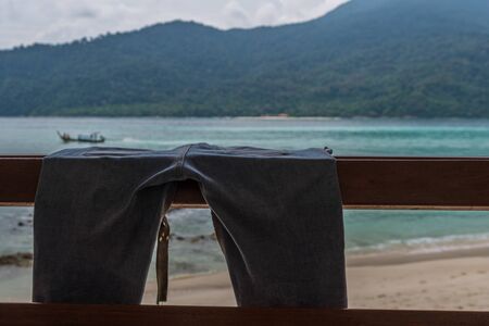 Blue jeans hanging on terrace with beach background.の写真素材
