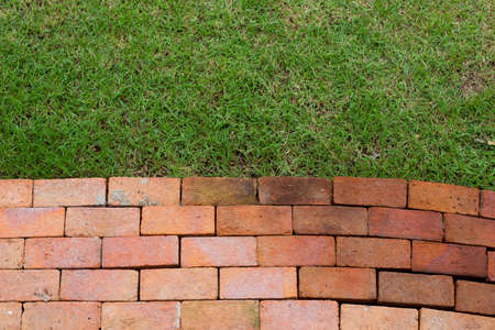 Red brick  and grass field backgroundの写真素材