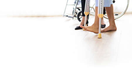 The doctor giving treatment to the woman patient broken leg. Doctor and female patient are...