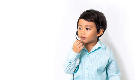 Child as a businessman in a video conference. Cute Asian boy in VOIP Helpdesk headset. Kid customer...