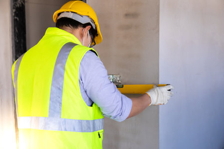 Asain worker using water level meter measuring the wall builder on the construction site. Building  bubble level tool.の写真素材