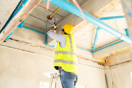 Asian man construction worker holding pipe and working on site.の写真素材