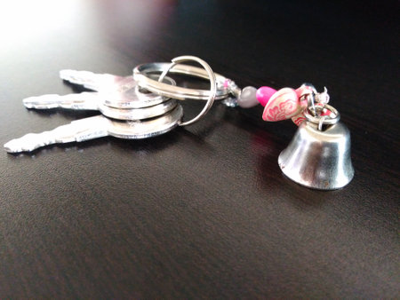 Key ring and bell on a black background, closeup of photoの写真素材