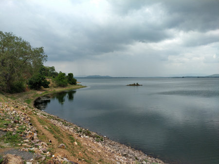 View of the lake with cloudy sky and mountain in the background.のeditorial素材