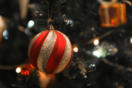 Christmas Silver red ball hanging on a beautiful Chrismas tree surrounded by red and white shinning ballの写真素材