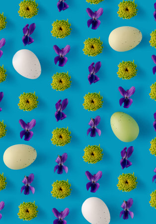 2021 Easter creative layout made with spring flowers (Sweet Violet, green Button Pom Chrysanthemum) and white Easter eggs on light pastel blue background. Minimal holiday still life composition.の写真素材