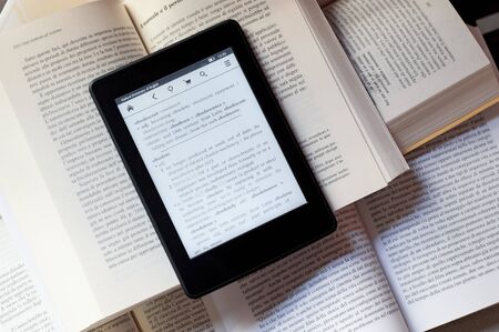 An ebook reader over several booksの写真素材