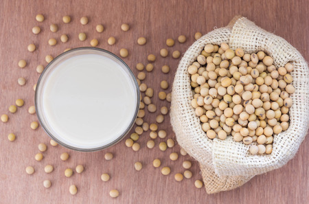 Soybean in hemp sack bag on a wooden background.の写真素材