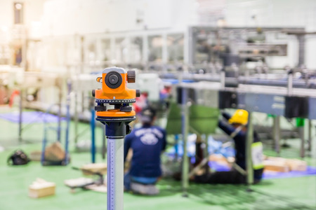 Construction surveyor equipment theodolite level tool during workers installing machine at backgroundの写真素材