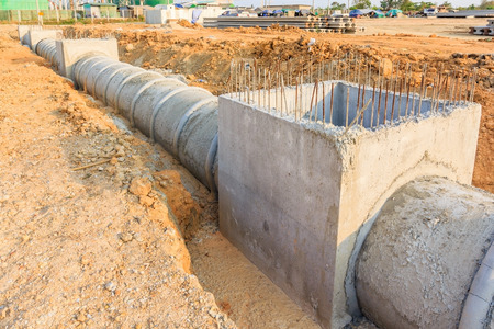 Concrete Drainage Pipe and manhole on a construction Site .Concrete pipe stacked sewage water system...