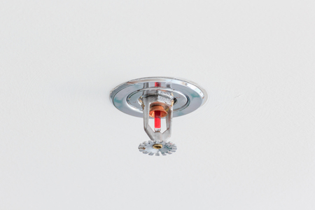 Close up image of fire sprinkler on white background. Fire sprinklers are part of an integrated water piping system designed for life and fire safety.の写真素材