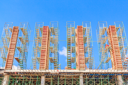 Building construction site, scaffolding on a construction pillar at a construction site with labours...