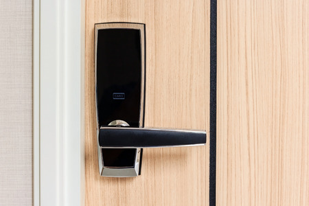 electronic door lock with card access on wooden door in apartment, safety area for high securityの写真素材