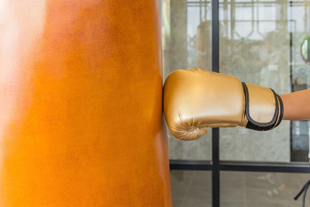 Close-up women hand of boxer at the moment of impact on punching bag in gymの写真素材