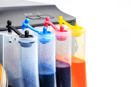 Setting up modified ink tank for inkjet printer. Printer color ink tank beside isolated on white backgroundの写真素材